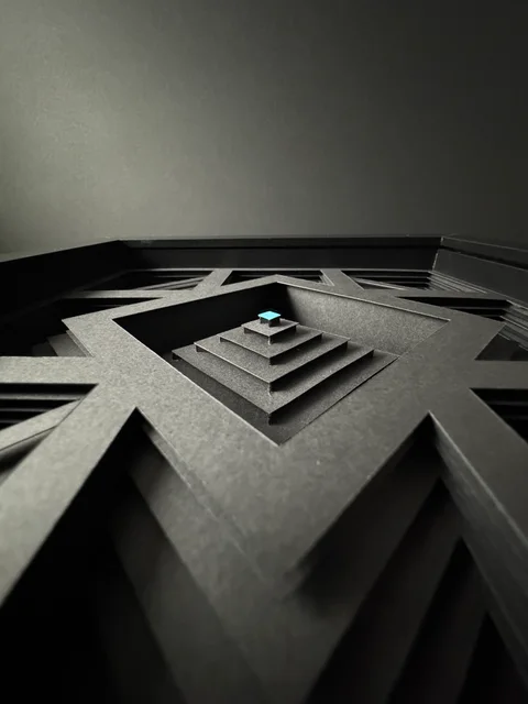 NF-02. Low view across the stepped paper construction toward its pale cyan center.
